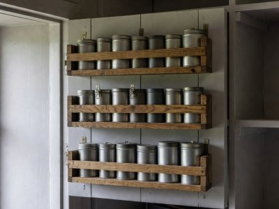 Timber spice and condiment racks mounted inside a heavy painted cottage larder door